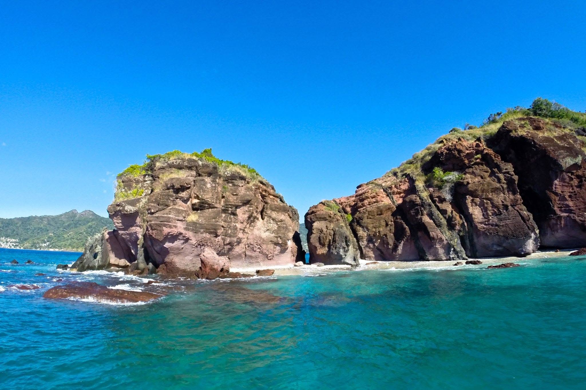 Falaises rouges plongeant dans les eaux turquoise du lagon